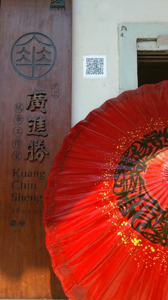 An red oil-paper umbrella on display at the entrance to KCS Oil-Paper Umbrella Studio.