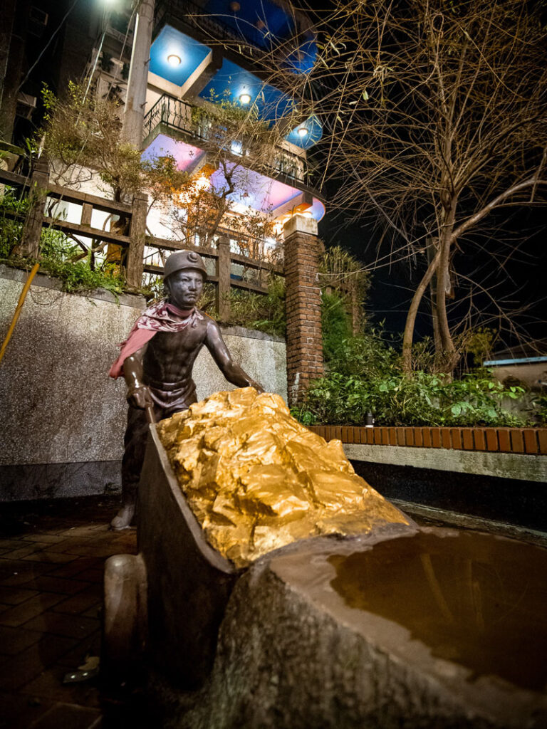 A statue of a gold miner pushing a cart in Jiufen.