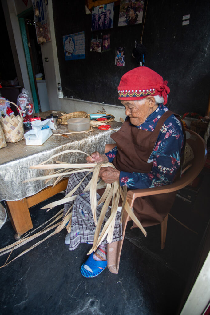 An elderly woman of over 90, works on tribal handicrafts.