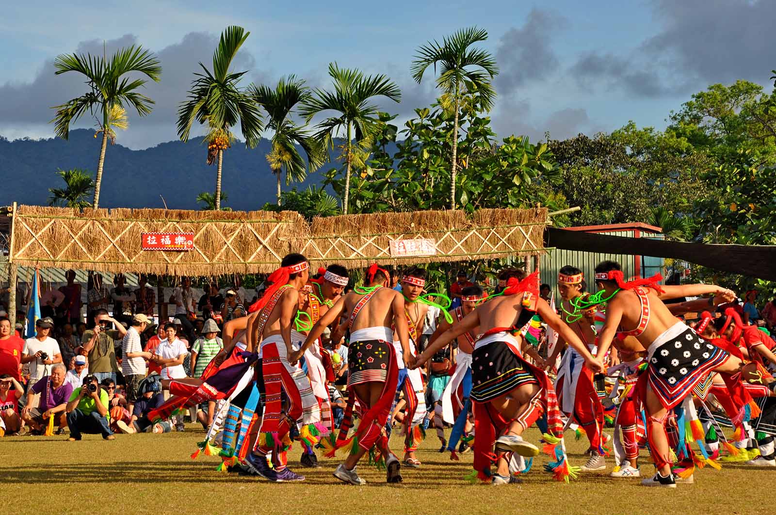 A group of Amis, dressed in traditional attire, are performing a dance during their tribe's Harvest Festival.