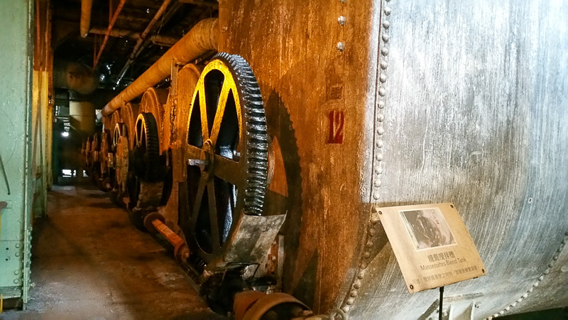 Large gears on the side of a blend tank in Ten Drums Culture Village.