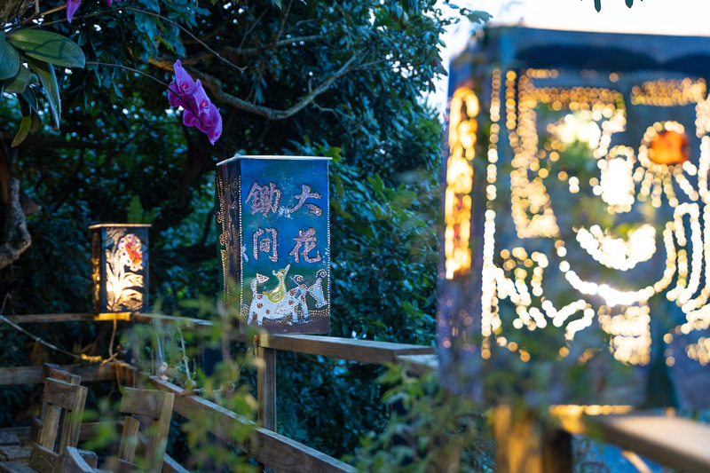 Decorative lanterns illuminate the wooden deck of Dachu Coffee Estate.