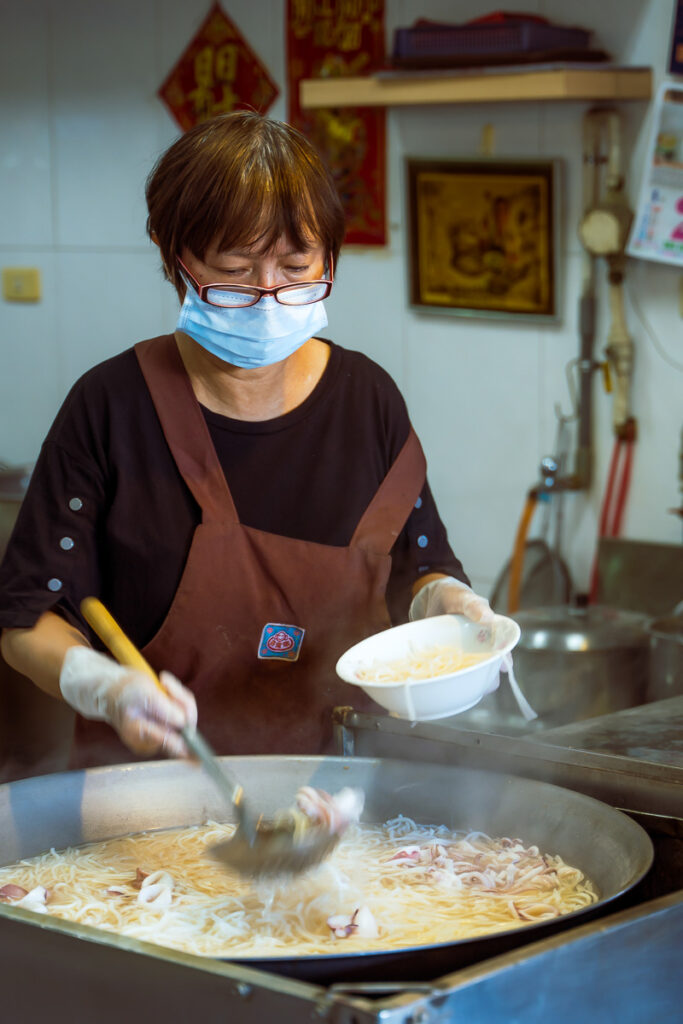 A street stall owner serving soup.