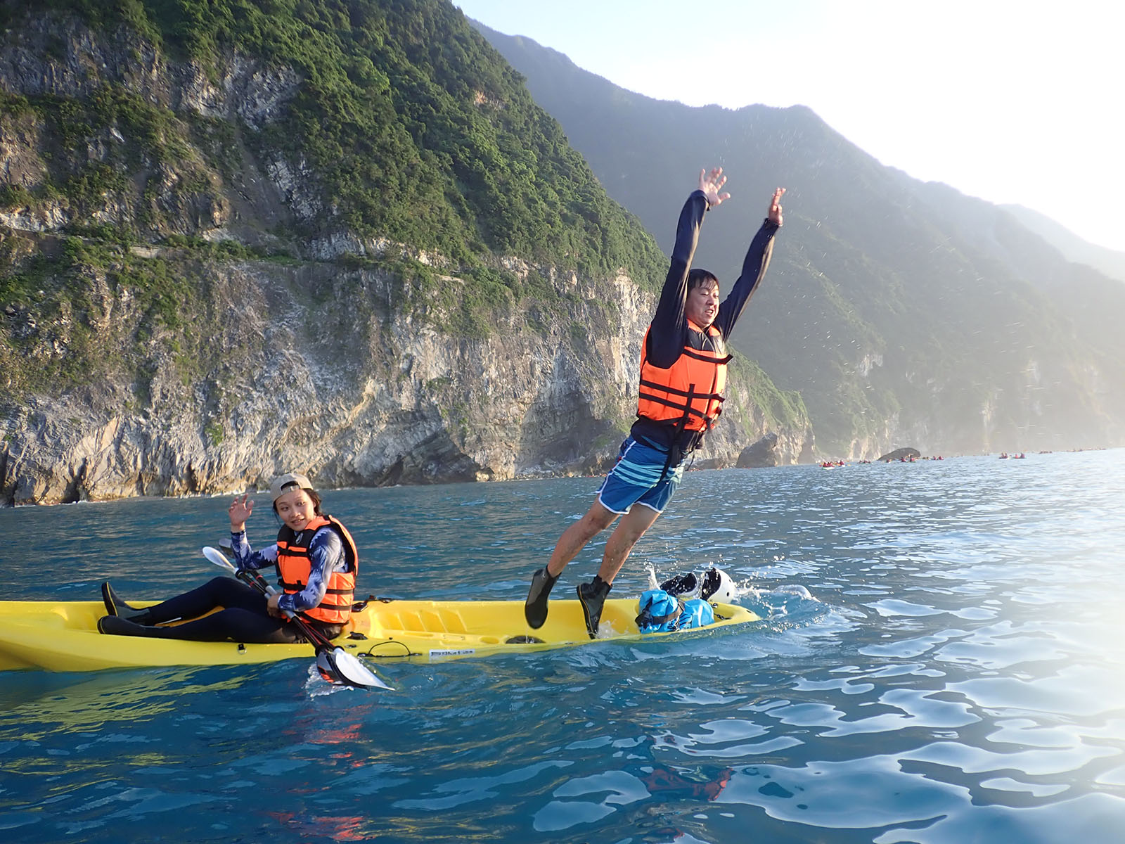 A tourist jumps off a kayak in front of the Qingshui Cliffs.