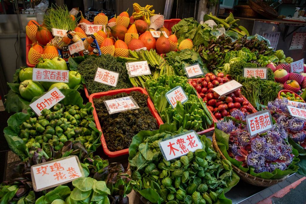 Indigenous restaurants display their foraged mountain vegetables on Wulai Old Street.