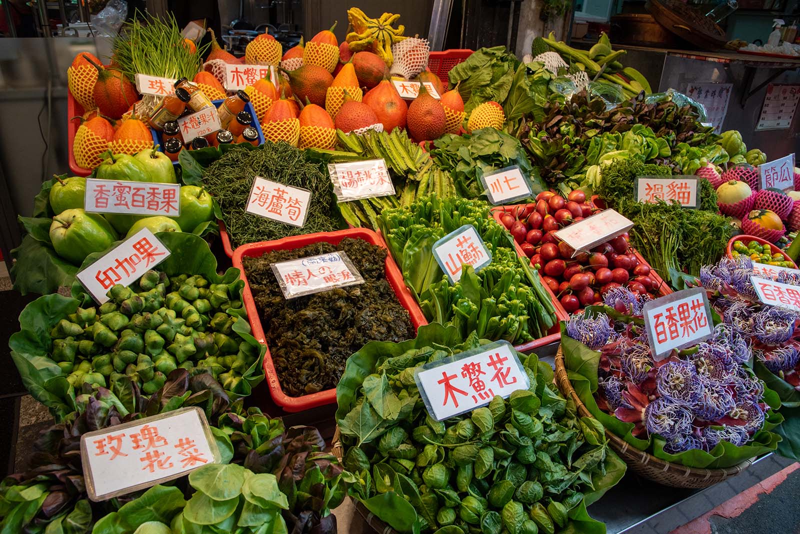 Indigenous restaurants display their foraged mountain vegetables on Wulai Old Street.