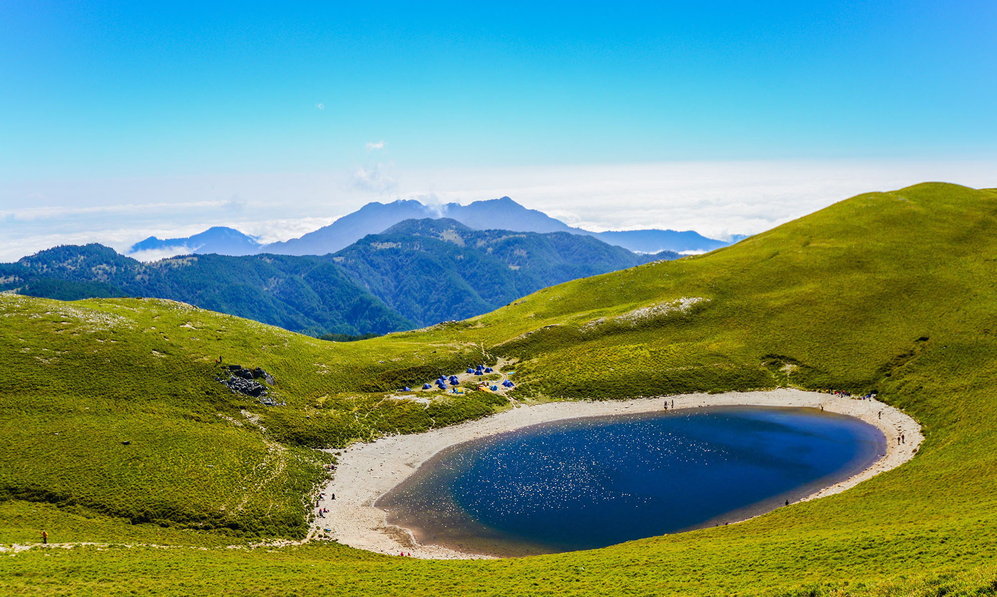 Hikers and tents can be seen at Jiaming Lake on the Jiaming Lake National Trail.