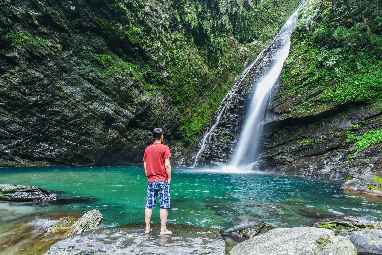 A traveler stands appreciating Aohua Waterfall in Heping, Yilan.