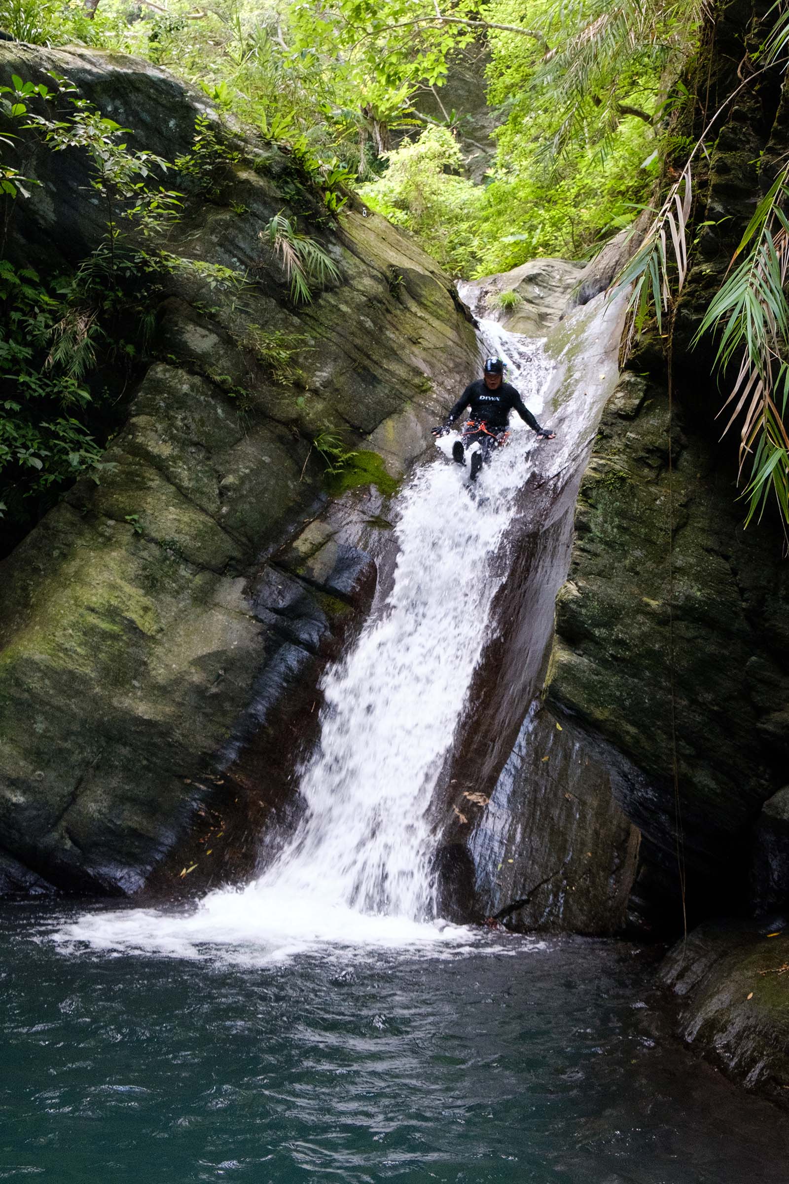 Sliding down a natural waterslide during a tour through Guanyin Creek.