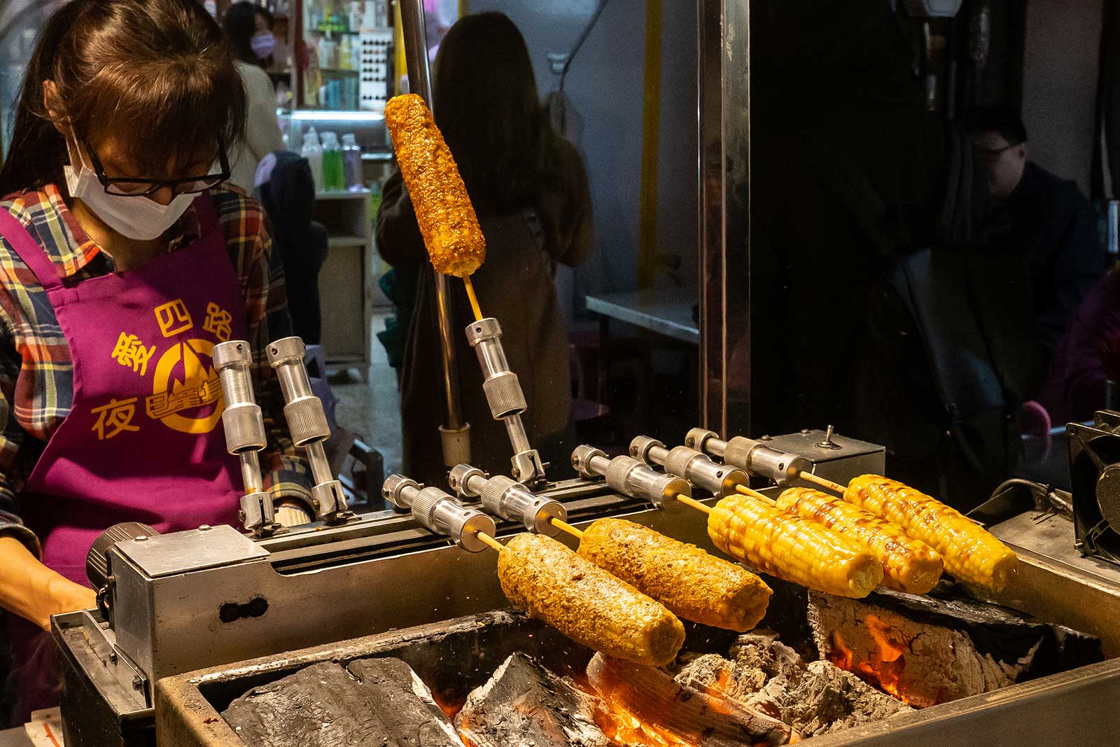 Corn on a cob cooked over a wood-fueled flame.