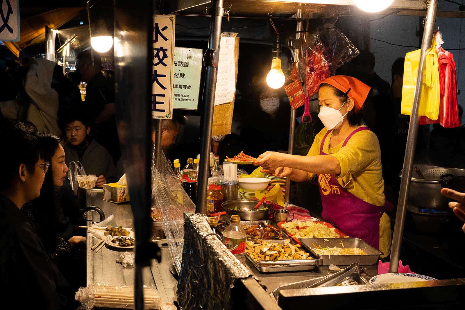 Tourists eat seafood in a night market.