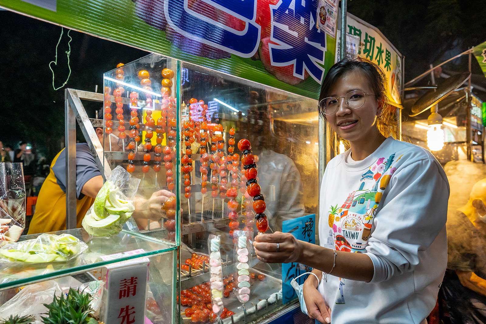 Buying a glazed fruit skewer.