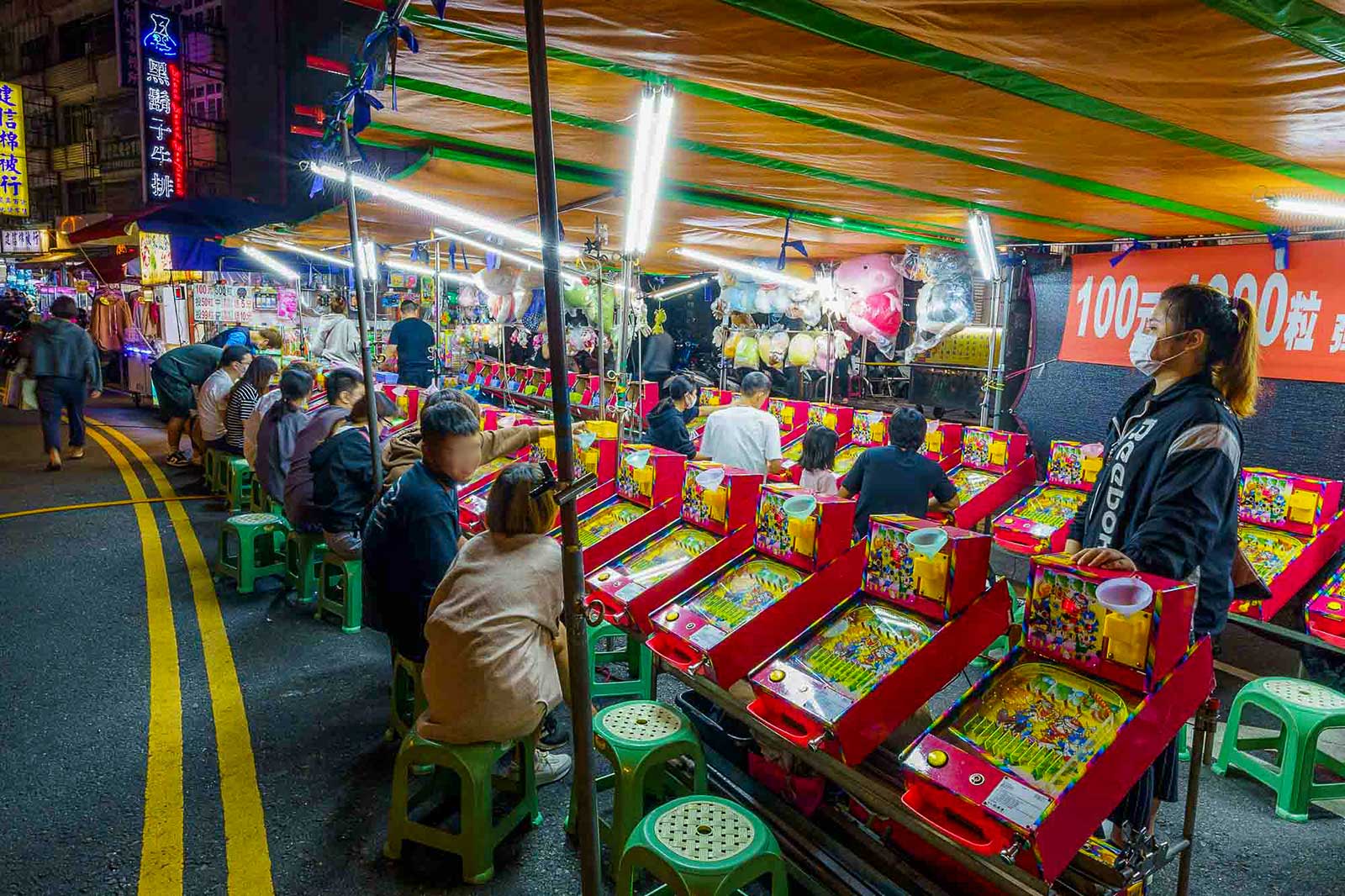 Children play games in a night market.