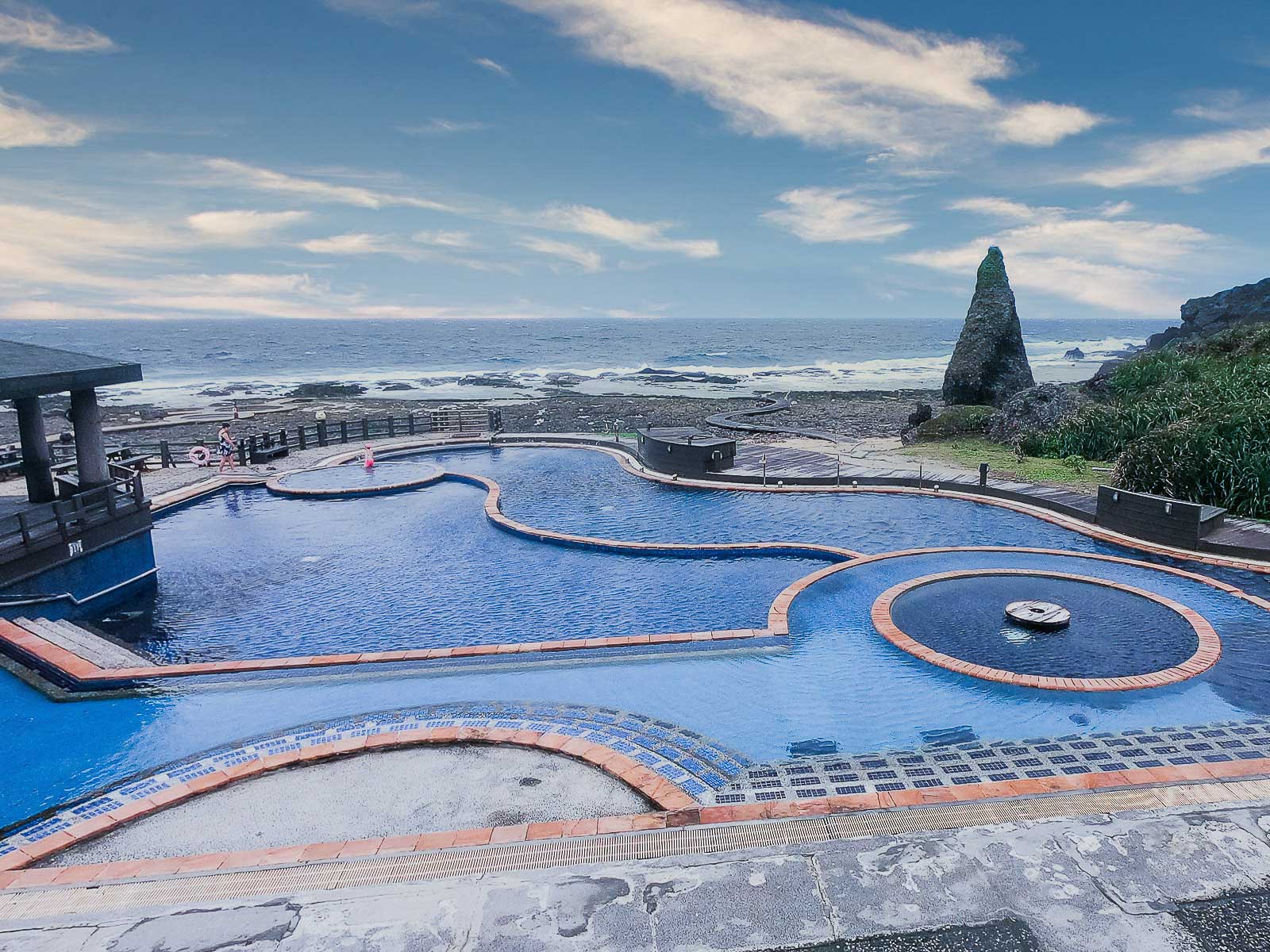 Multiple tiers of hot spring pools lead down to the volcanic coast at Green Island's Zhaori Hot Spring.