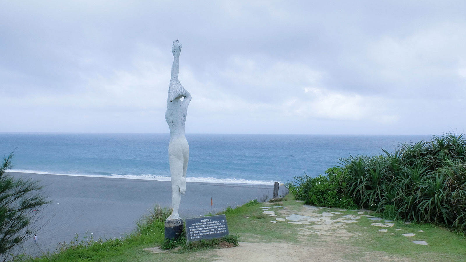 A tall sculpture stands at the entrance to Niushan Beach.