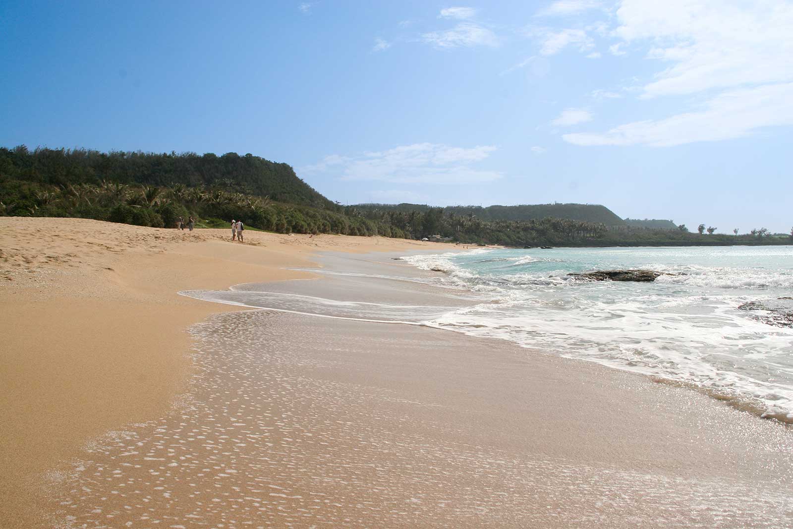 A gentle wave crashes on the pristine yellow sand of Baishawan Beach in Kenting.