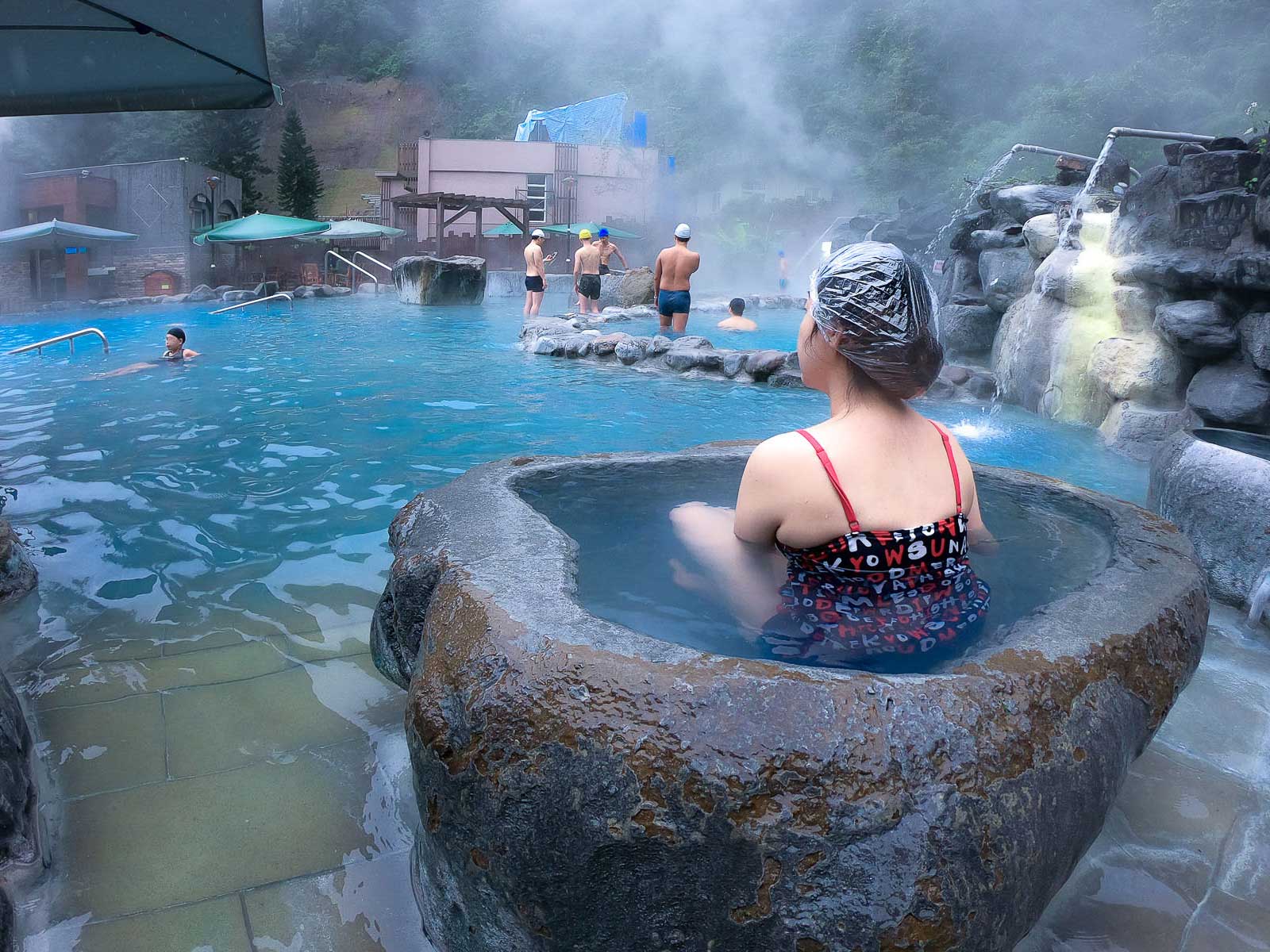 A bather enjoying a private hot spring pool within the larger public open-air hot spring at Jioujhihze Hot Spring.