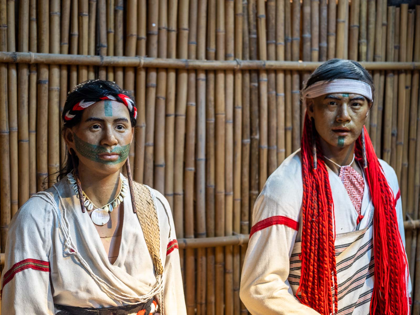 Two models wear traditional Truku clothing and Truku face tattoos.