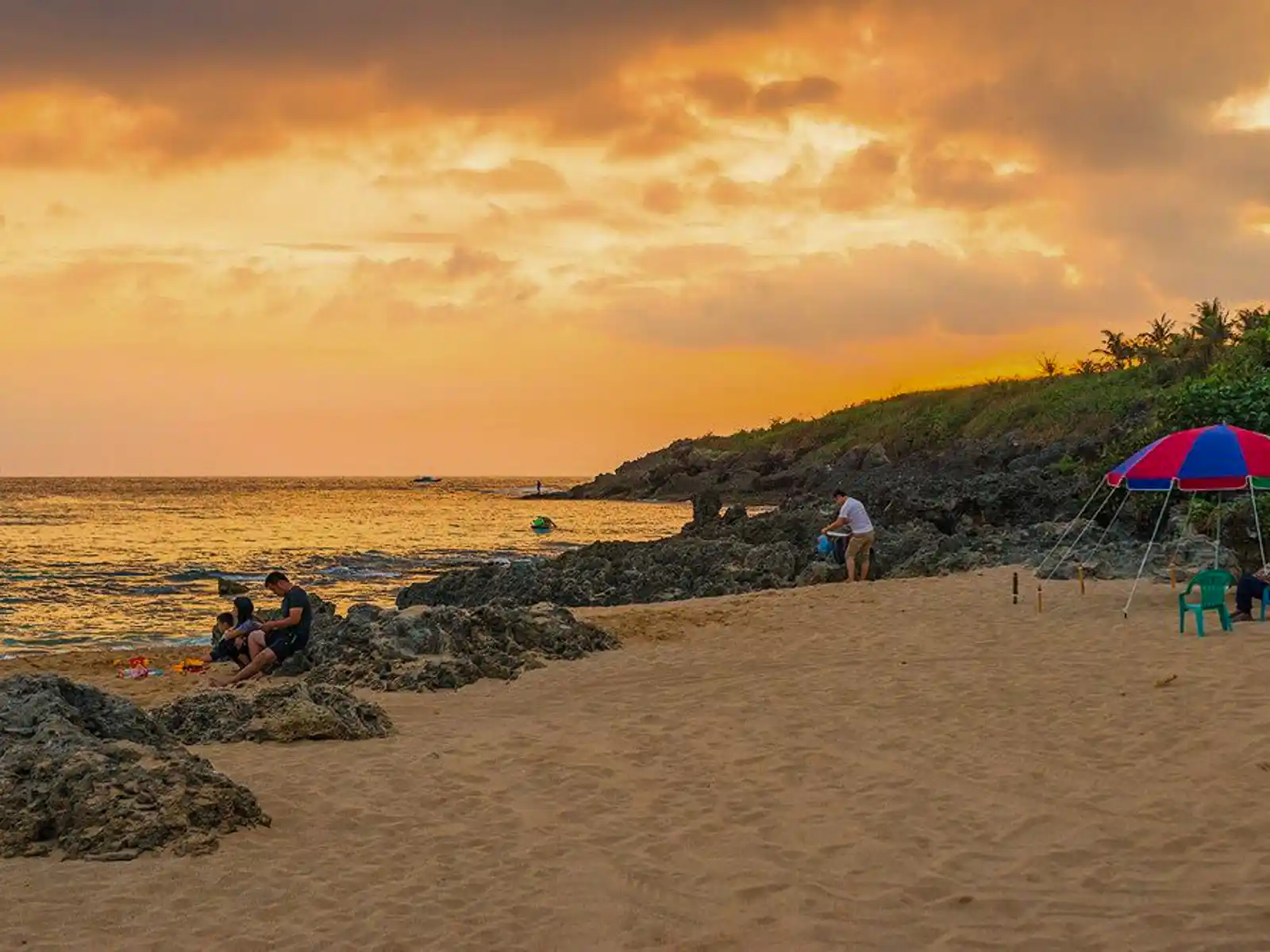 Illuminated by the sunset, the sky glows orange above Baishawan Beach.