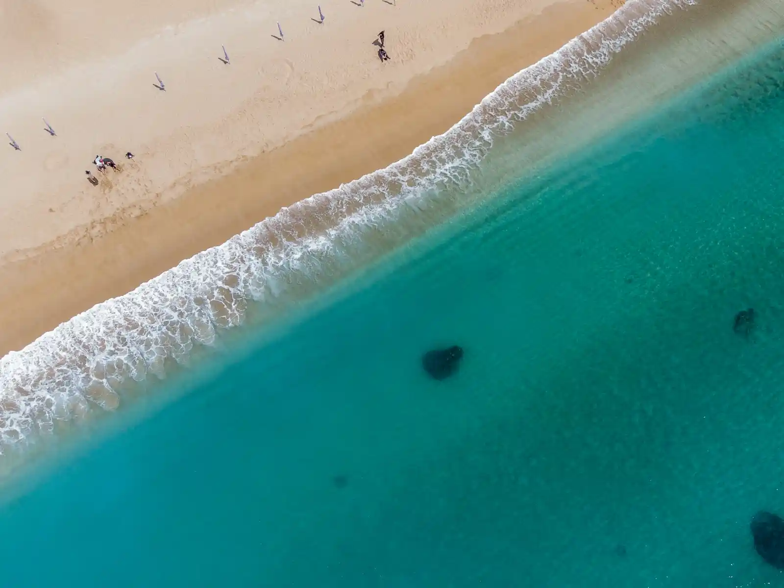 Golden sand meets clear turquoise water.