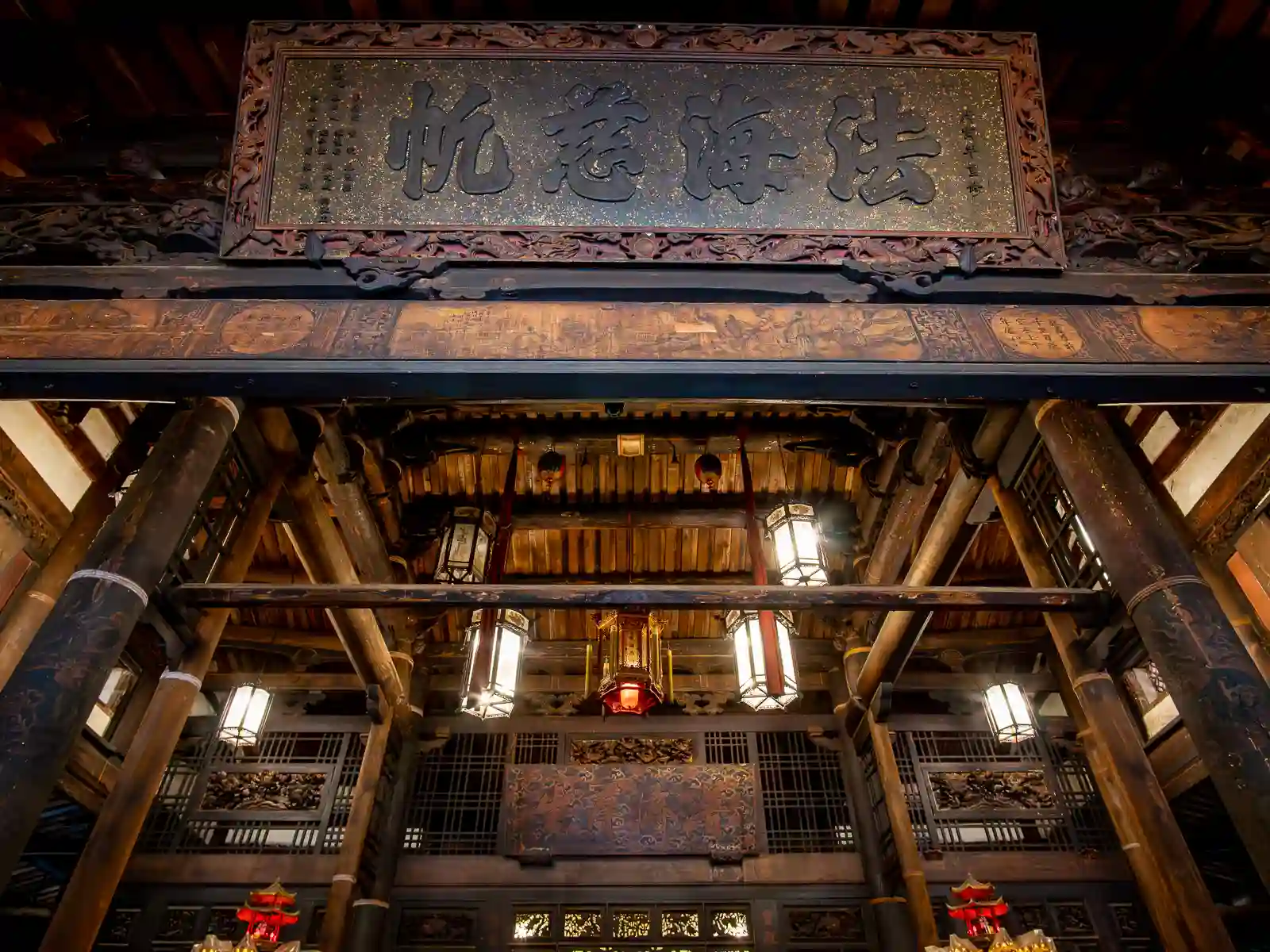 Intricate carvings are visible on several panes in the ceiling of one of Longshan Temple's halls.