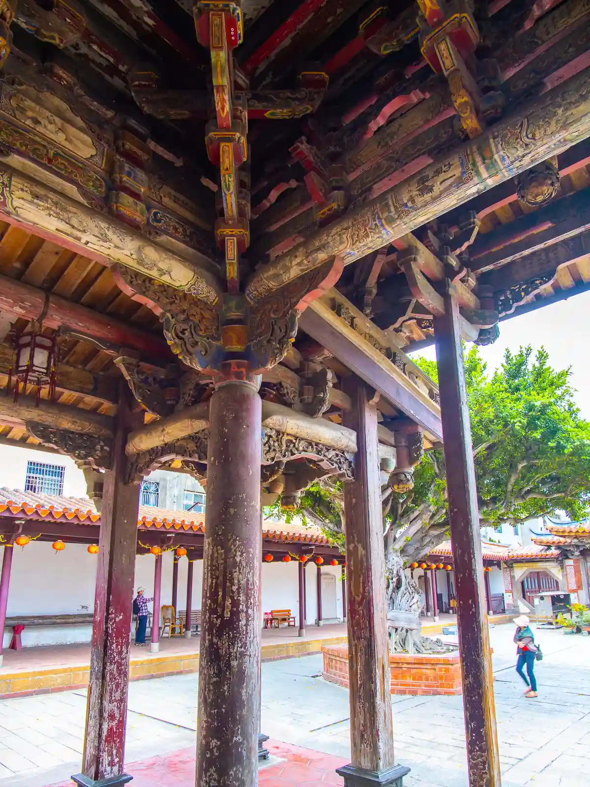 Aged paint is visible on the massive wooden columns supporting the temple's Theatre Pavilion.