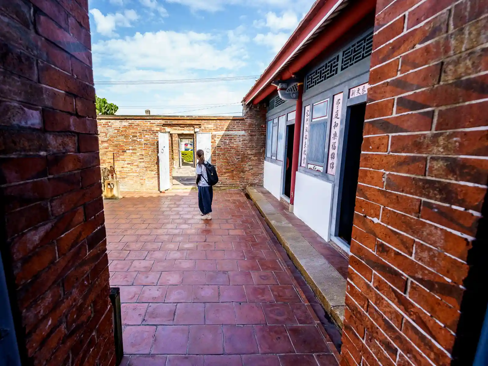 A tourist walks around one of the red-brick courtyards in Ting's Family Historical Residence.
