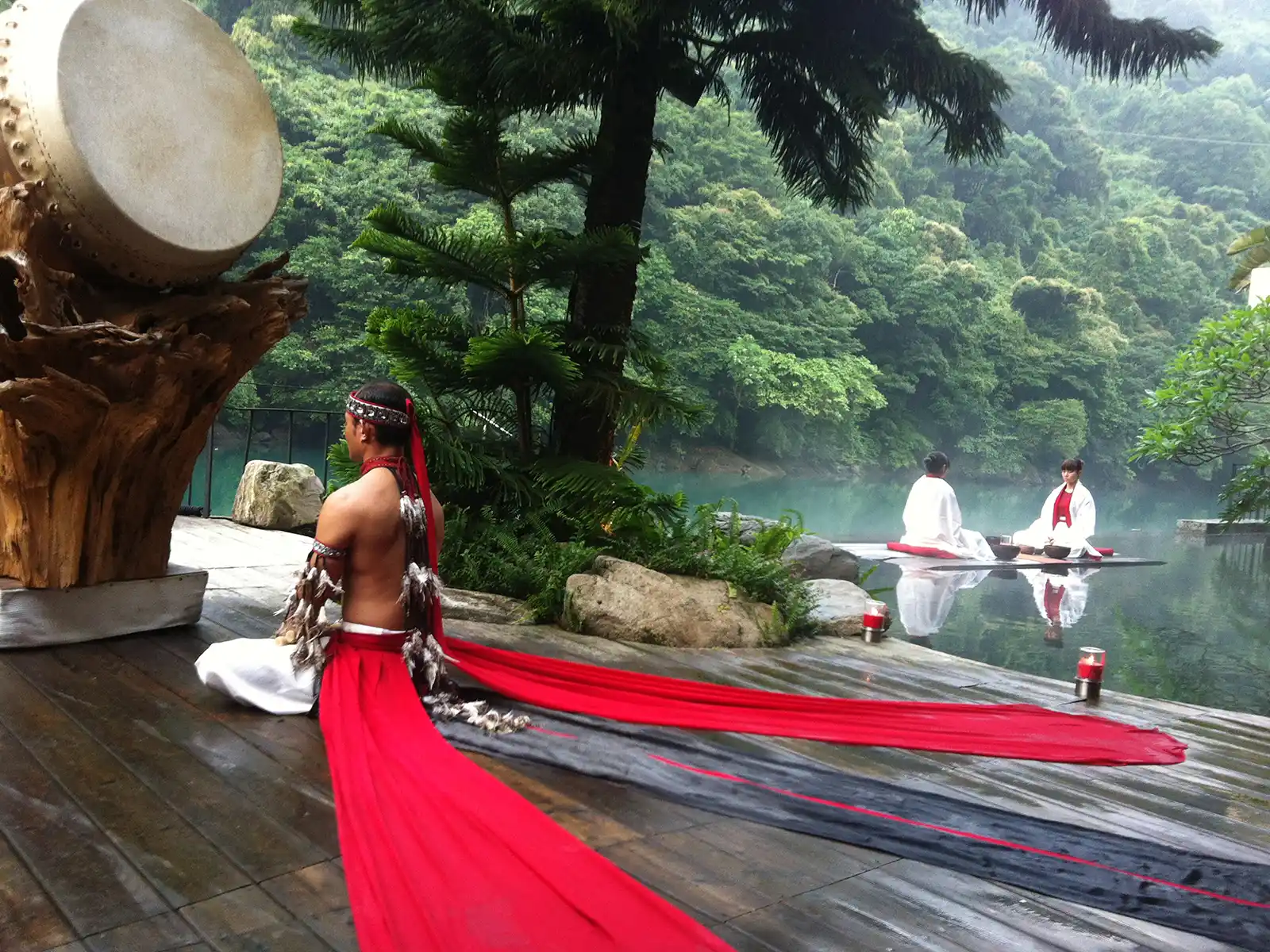 An employee in indigenous attire participates in a lakeside ceremony.