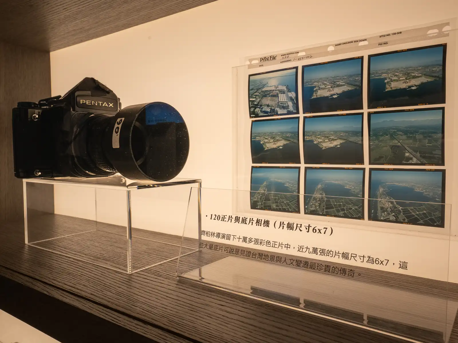 A medium format camera on display along with photos.