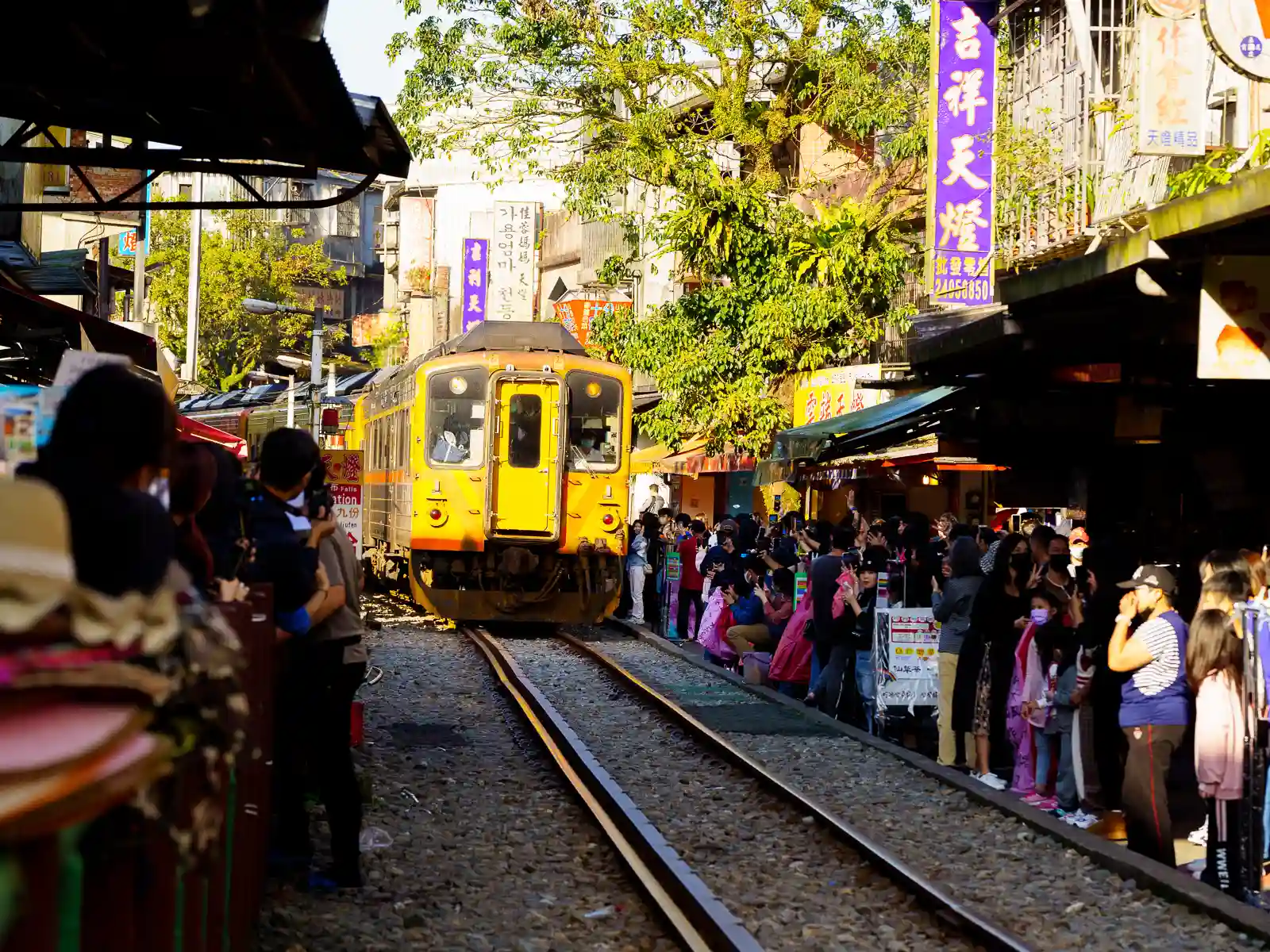 Tourists gather on the sides of Shifen Old Street as as a train from the Pingxi Rail Line passes through the middle of town.