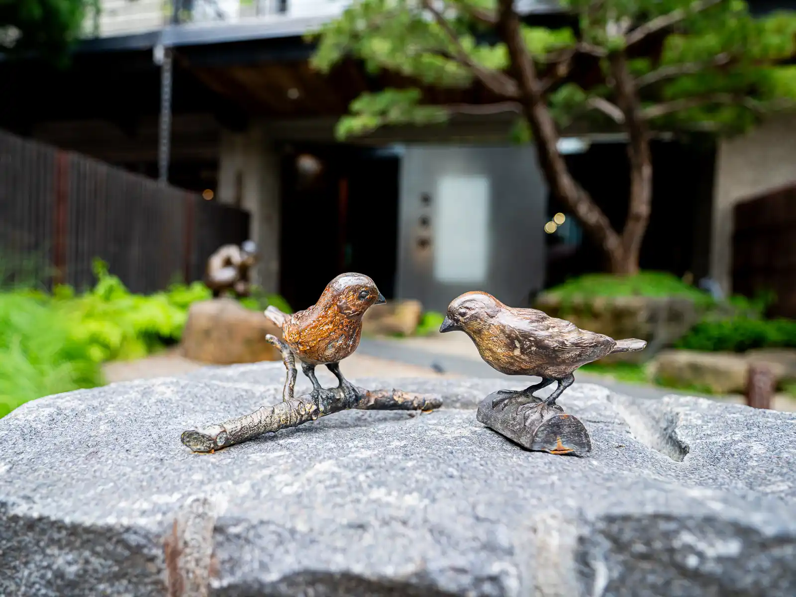 A small sculpture of two birds is on display outside.