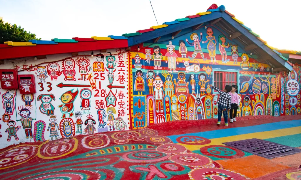 In Taichung’s Rainbow Village, a mural covers everything visible from the roof tiles of a building, to its walls and mailbox, to the cement road surface before it.