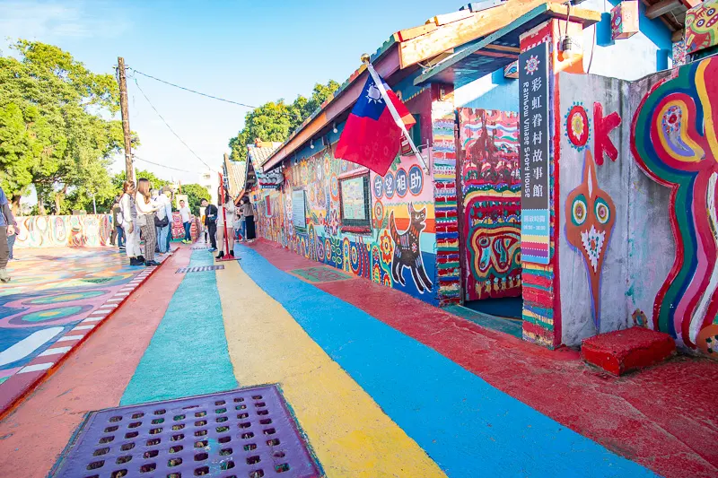 The Taiwanese flag is on display above a doorway in courtyard that has been completely decorated with cute murals featuring animals and abstract human shapes.