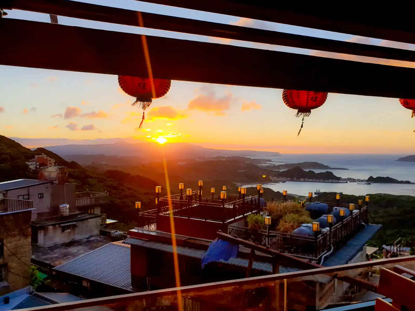 The sun can be seen setting over the mountains of Ruifang from the balcony of Amei Tea House.