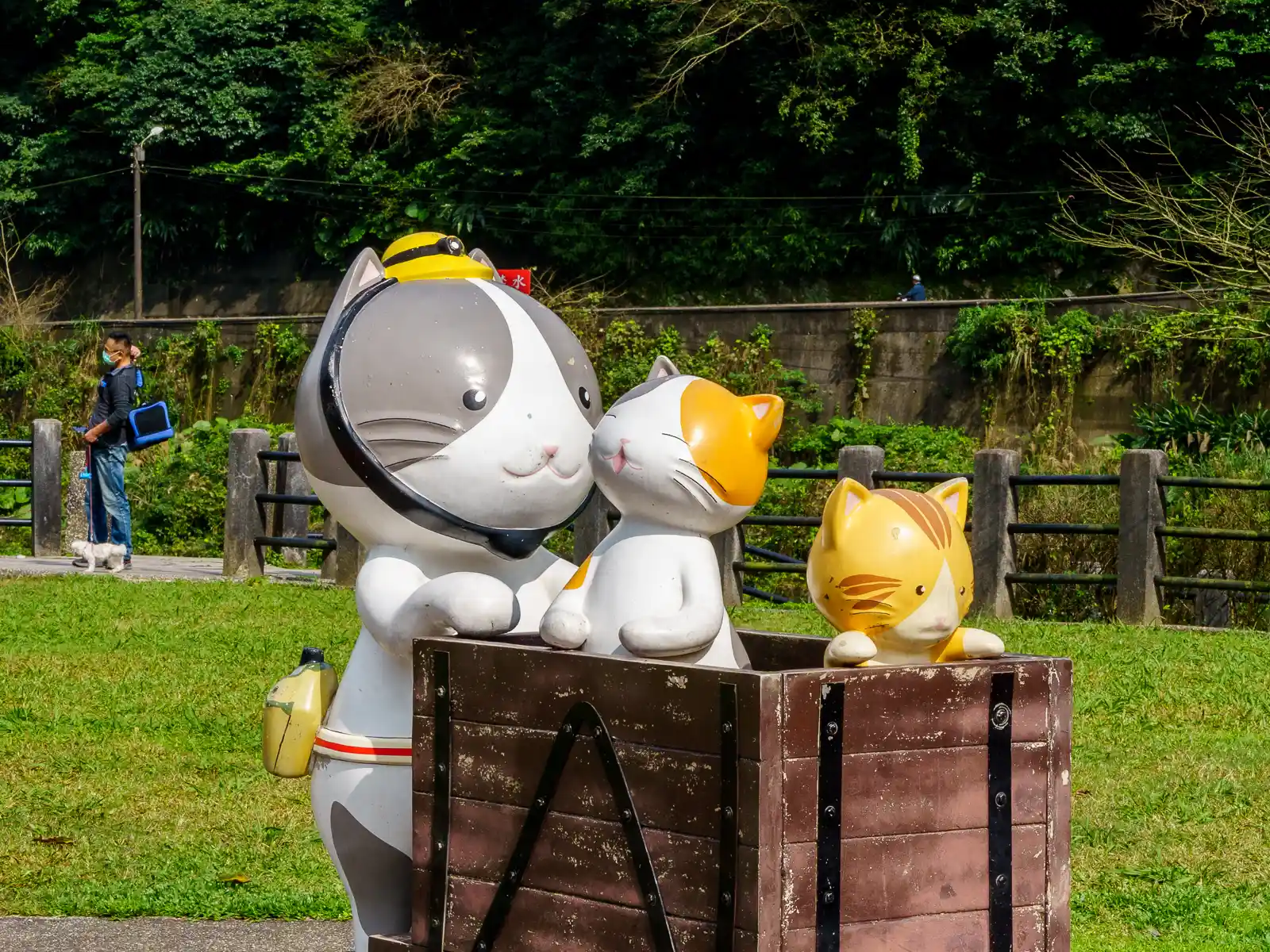 A statue of three cats and a mining cart in Houtong.