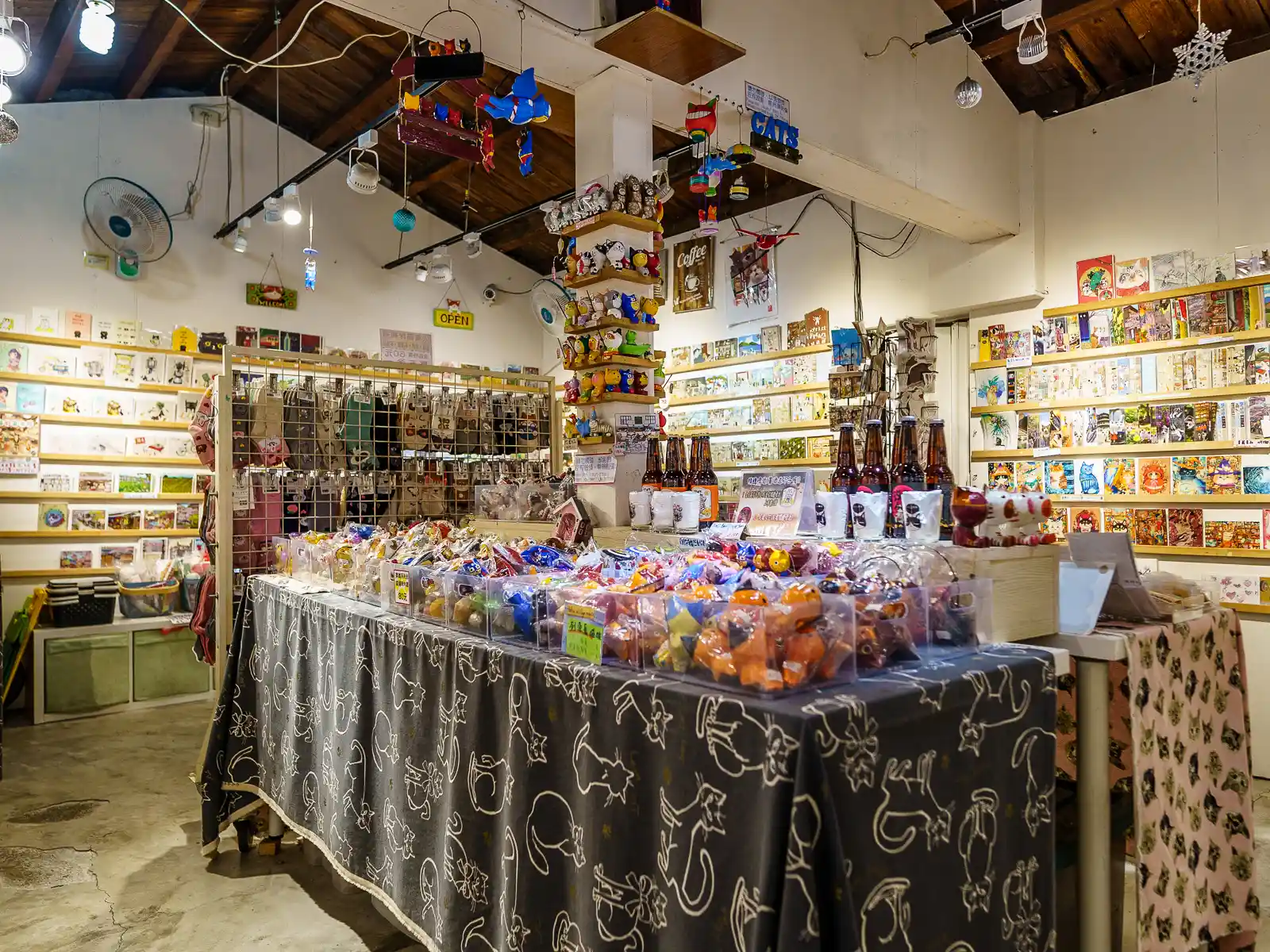 A multitude of multi-colored cat-oriented souvenirs and goods line the walls and tables inside the store.