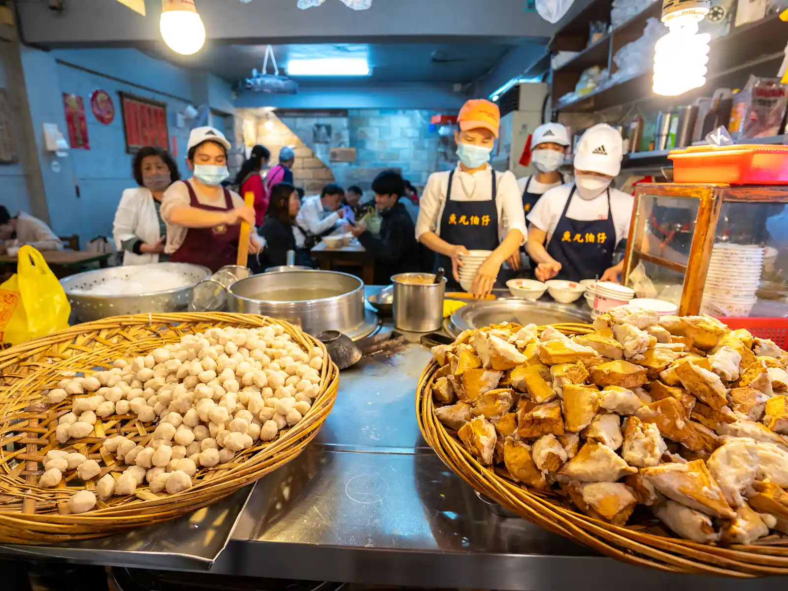 Fish balls and tofu are on display in front of an eatery.