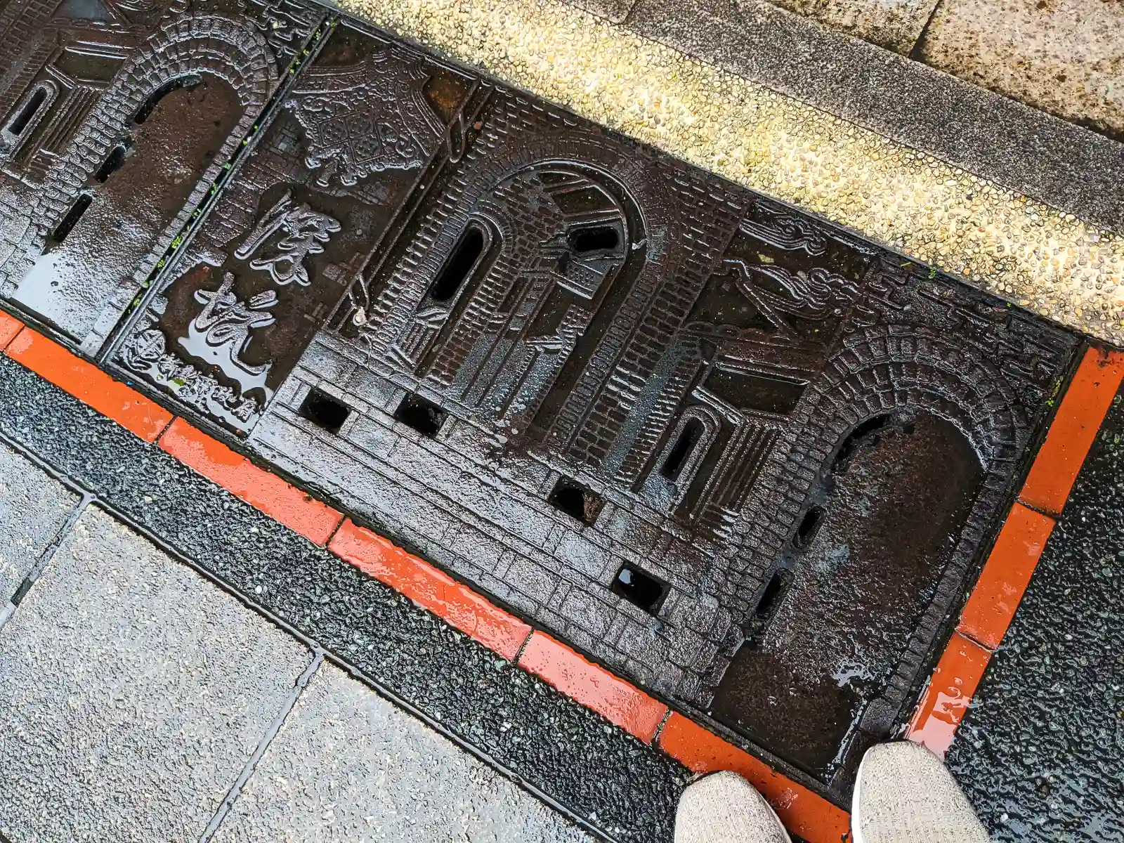 A sewer lid in Shenkeng Old Street is decorated with a relief of the scenery of the old street.