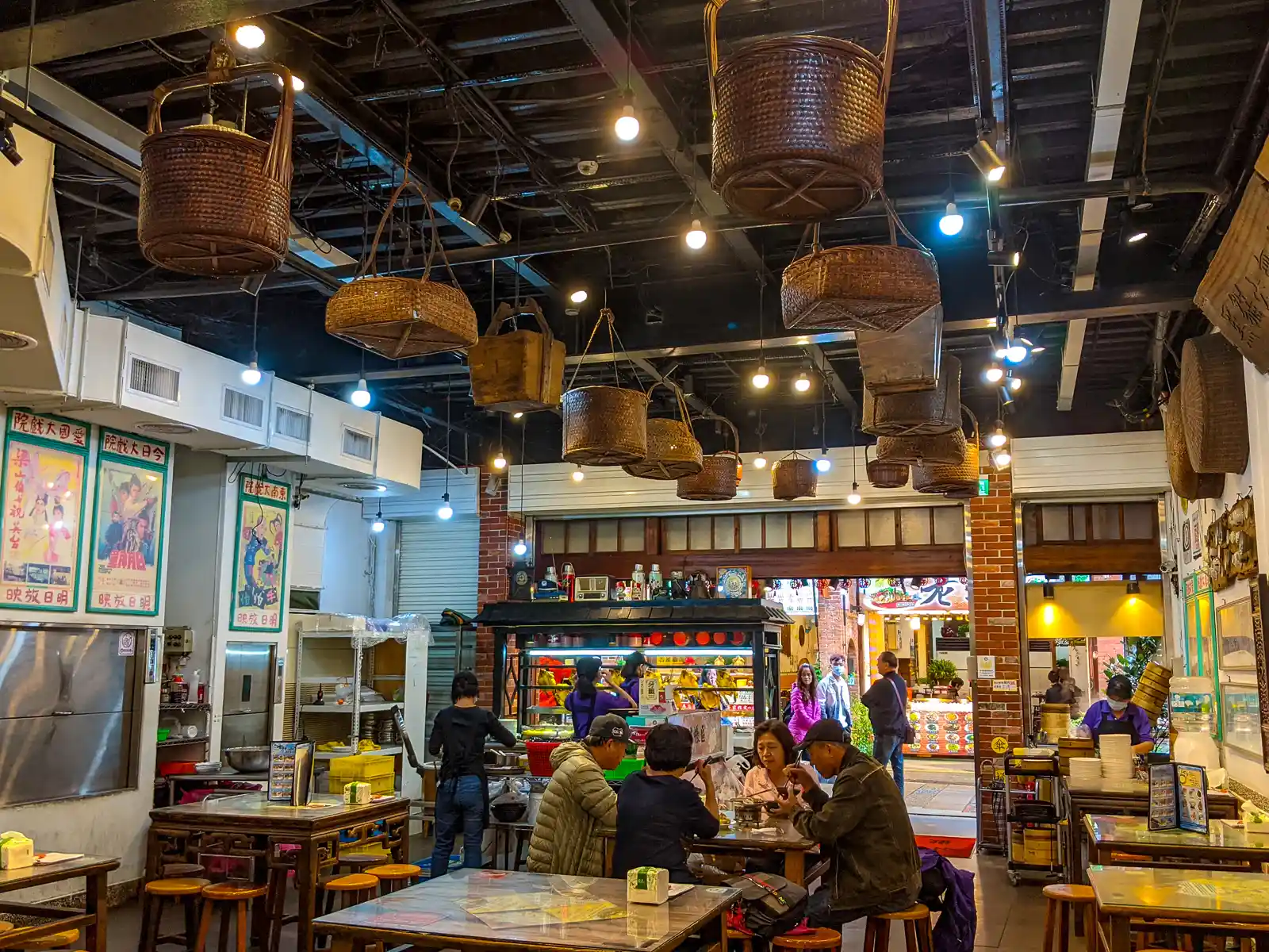 A group of tourists are dining in the open-air first floor of one of the old buildings in Shenkeng.