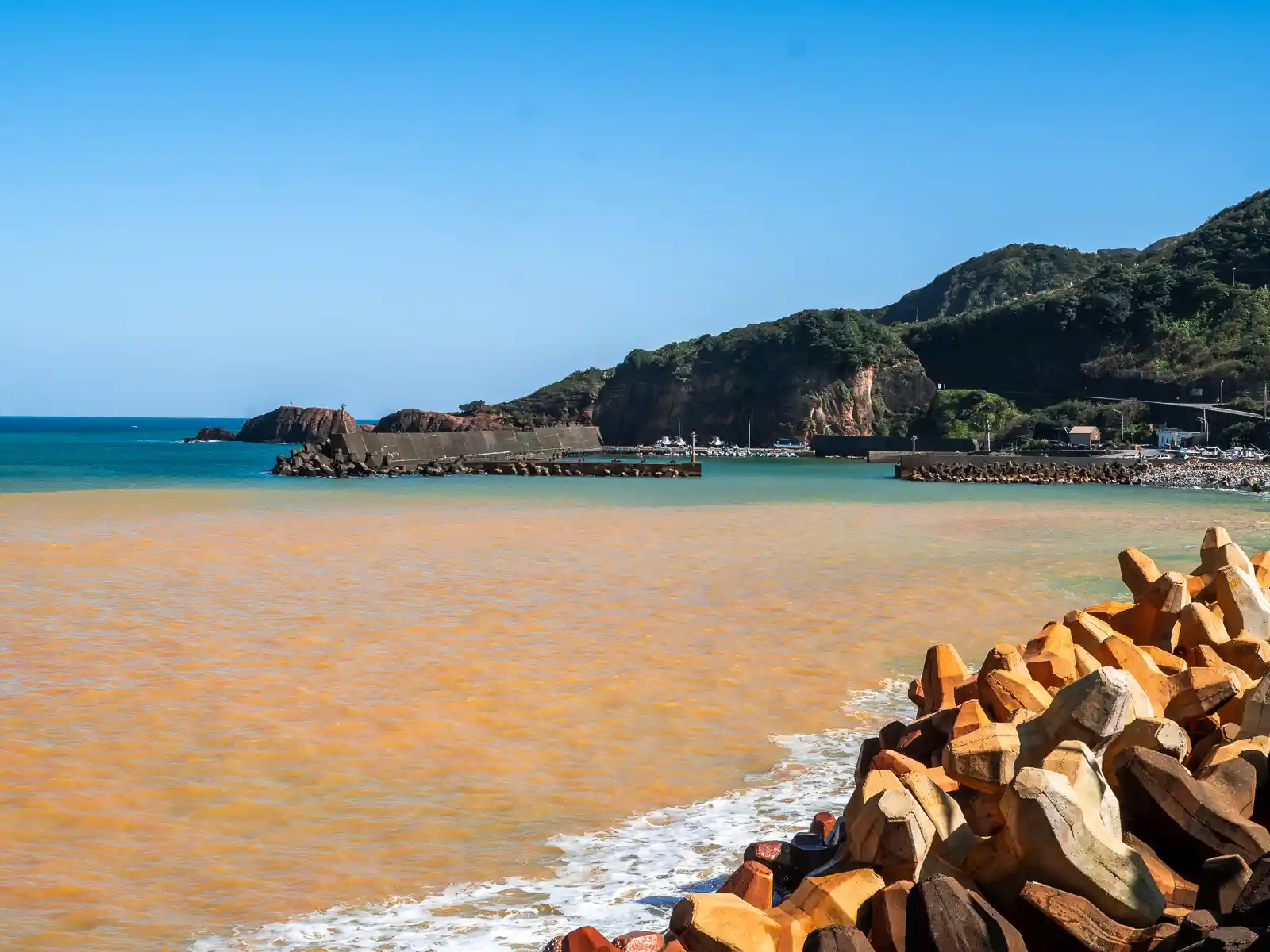 The yellow-brown water of the Yinyang Sea gradually mixes with ocean water along the shore.