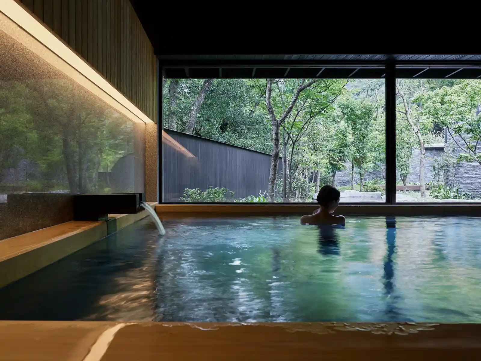 A tourist soaks in an indoor pool at the luxury Hoshinoya hot spring resort.