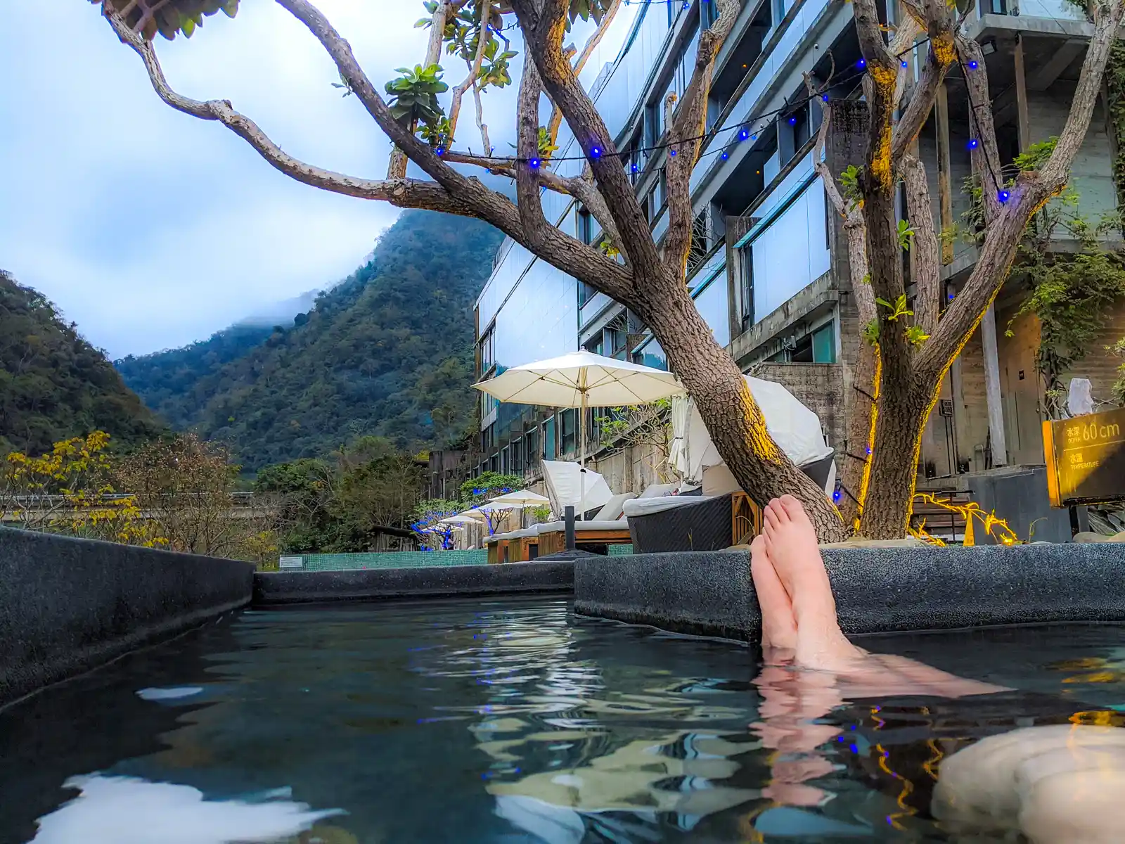 A person's feet can be seen coming out of the water as they soak in a hot spring.