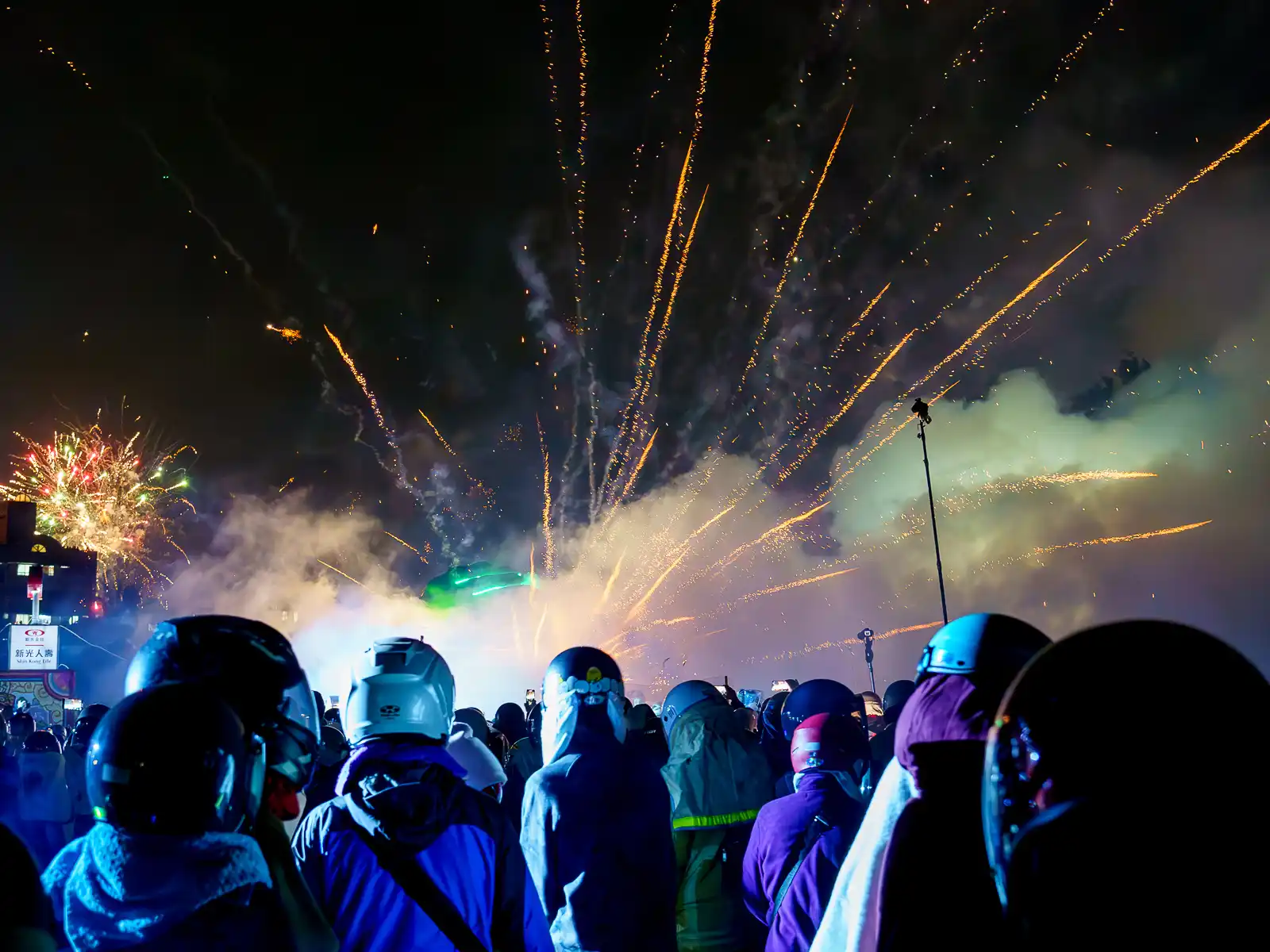 A barrage of fireworks is erupting and shooting both up and into the crowd as well as the camera.