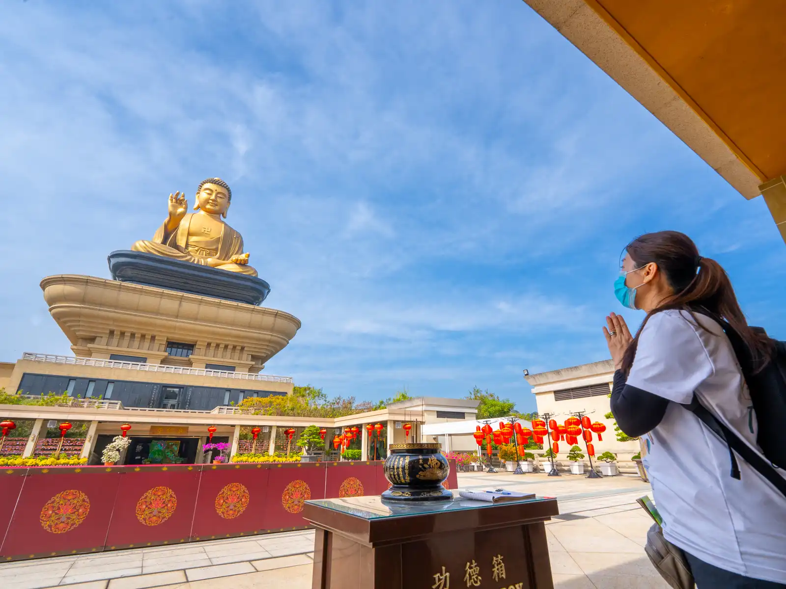 A tourist prays in front of the Fo Guang Big Buddha.