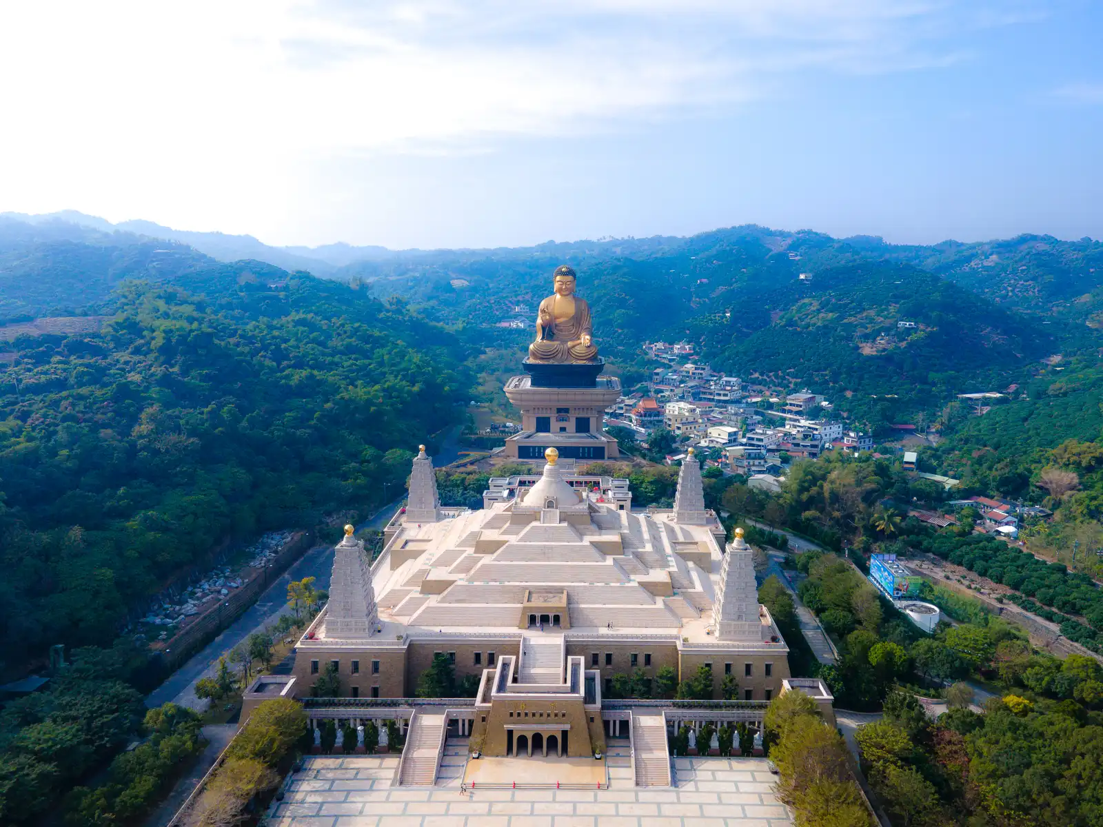 The Four Noble Truths Stupas, Main Hall, and Fo Guang Big Buddha as well as the surrounding forested hills are seen from above.