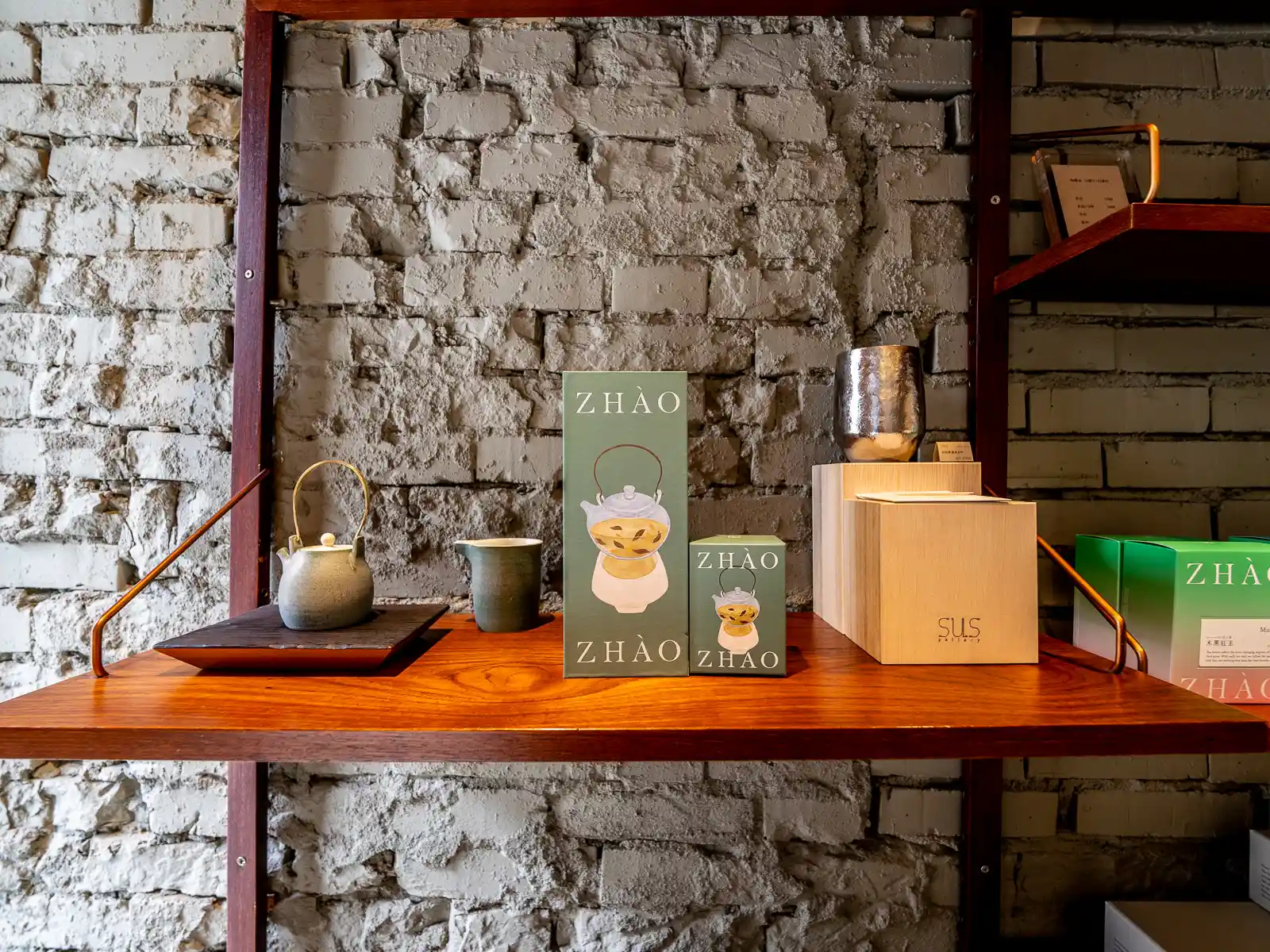 Locally made ceramics and tea accessories are on display on a shelf in Zhao Zhao Tea Lounge.