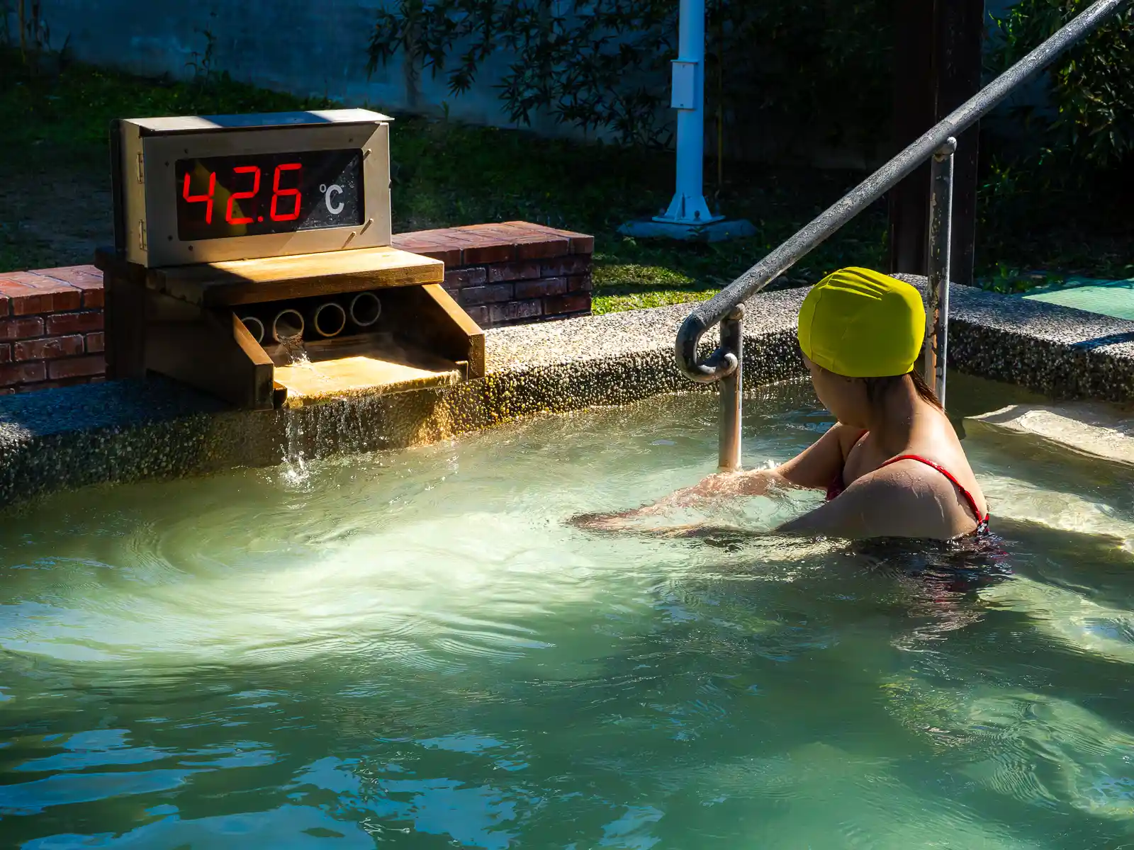 A tourist bathes in an outdoor hot spring pool which is measured to be 42.6 degrees Celsius.