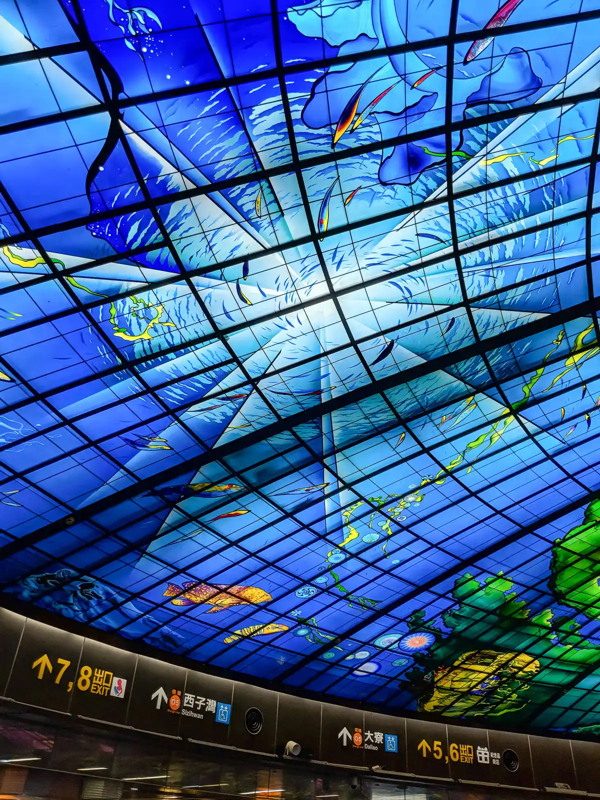 A part of the glass artwork shows a swirling underwater scene filled with fish and sea creatures.