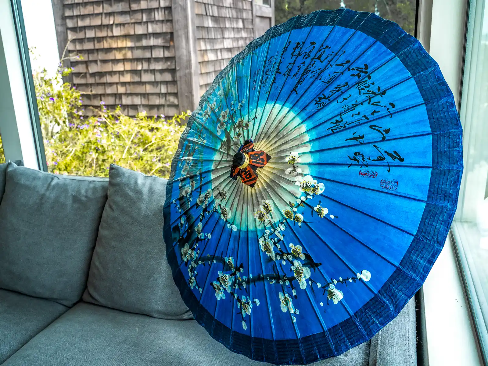 A beautiful indigo-colored oil-paper umbrella is on display indoors.