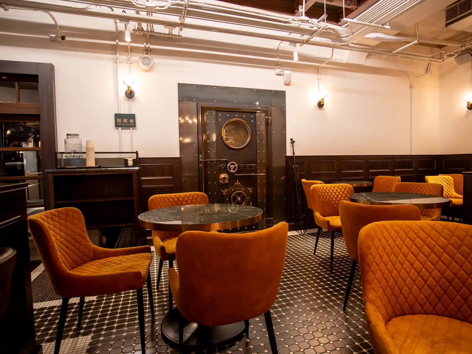 The entrance to a bank vault can be seen in the retro-styled seating area.